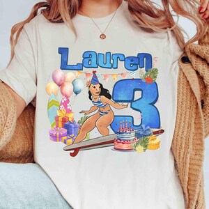 Puede incluir: Camiseta color crema con una ilustraci&oacute;n de dibujos animados para un cumplea&ntilde;os. El dise&ntilde;o incluye el nombre "Lauren" en azul, un gran n&uacute;mero "3" azul, un personaje de dibujos animados en traje de ba&ntilde;o, globos, regalos y una tarta de cumplea&ntilde;os.