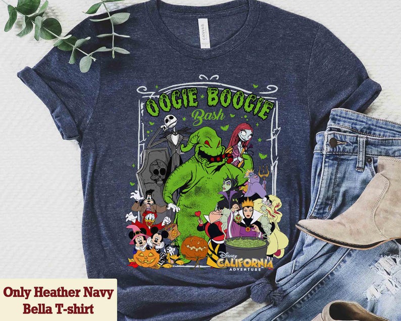 Puede incluir: Camiseta Heather Navy Bella con un gr&aacute;fico de Oogie Boogie Bash de Disney. El dise&ntilde;o incluye personajes como Jack Skellington, Oogie Boogie, Sally y otros villanos. La camiseta tambi&eacute;n tiene el texto "Disney California Adventure".