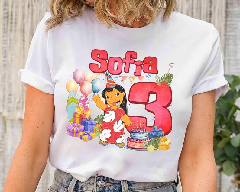 Puede incluir: Camiseta blanca con un gr&aacute;fico colorido para un tercer cumplea&ntilde;os. El dise&ntilde;o incluye el nombre "Sofia" en letras rojas, un personaje de dibujos animados, globos, regalos y una tarta. El n&uacute;mero "3" se muestra de forma destacada.