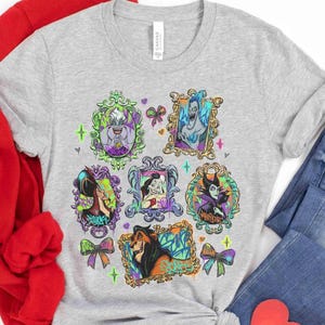Puede incluir: Una camiseta gris claro con retratos enmarcados de villanos de Disney. Los retratos est&aacute;n en marcos ornamentados con acentos coloridos, incluyendo lazos y corazones. La camiseta est&aacute; hecha de un material suave.