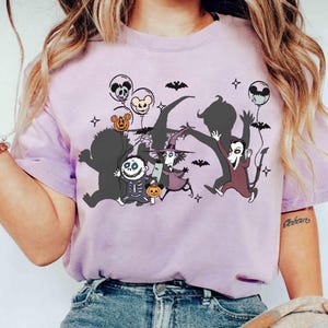 Puede incluir: Camiseta de color lila claro con un gr&aacute;fico de dibujos animados de personajes de Pesadilla antes de Navidad. El dise&ntilde;o incluye a Jack Skellington, Sally y otros personajes con globos y murci&eacute;lagos. La camiseta es de material suave.