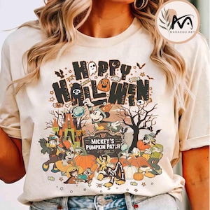 Pode incluir: Camiseta bege com um gráfico temático de Halloween. O design apresenta as palavras "Happy Halloween" com uma abóbora, uma caveira e morcegos. Abaixo, Mickey Mouse e seus amigos estão reunidos em "Mickey's Pumpkin Patch" com abóboras e um castelo assustador.