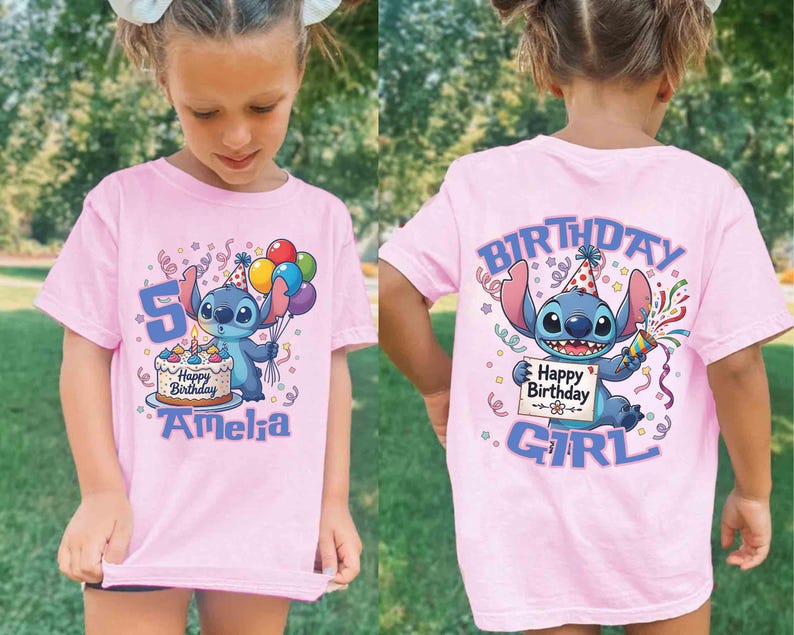 May include: Pink t-shirt featuring a cartoon character holding balloons and a birthday cake. The front of the shirt has the number 5 and the name "Amelia". The back of the shirt says "Birthday Girl" with the same cartoon character.