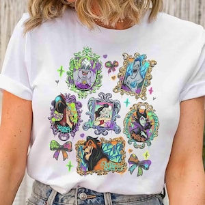 Puede incluir: Camiseta blanca con retratos coloridos de villanos de Disney en marcos ornamentados. Los retratos incluyen personajes como &Uacute;rsula, Jafar y Mal&eacute;fica, con detalles de estilo grafiti y lazos. Un dise&ntilde;o divertido y art&iacute;stico para los fans de Disney.
