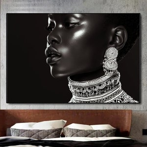 May include: Black and white portrait of a woman with a silver necklace and earrings. The background is black.