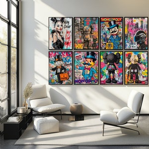 Puede incluir: Una colección de ocho impresiones de arte enmarcadas que presentan diseños gráficos coloridos. Las impresiones incluyen una mujer con una corona, un hombre Monopoly, un personaje de dibujos animados y un robot. Las impresiones están dispuestas en un patrón de cuadrícula en una pared blanca.