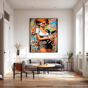May include: Pop art style print featuring a woman with red hair and glasses holding a black and white dog. The artwork has a graffiti-style background with splashes of color. The woman is wearing a white top and a gray skirt.