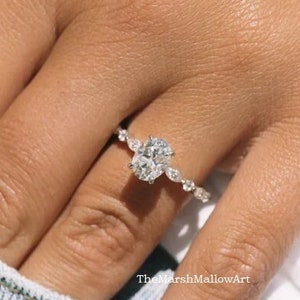 May include: A silver ring with an oval-shaped diamond and smaller diamonds on the band. The ring is on a person's finger.