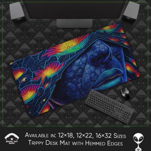 Op de afbeelding: Een psychedelische bureaumat met een abstract ontwerp in blauw, rood, geel en groen. De mat toont een close-up van een gezicht met een gesloten oog en een blauwe mond. De tekst "AVAILABLE IN: 12x18, 12x22, 16x32 SIZES" en "TRIPPY DESK MAT WITH HEMMED EDGES" staat onderaan de mat gedrukt.