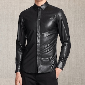 Pu&ograve; includere: Una camicia di pelle nera con maniche lunghe e bottoni. La camicia ha un colletto classico e viene indossata con pantaloni neri. Il materiale ha una leggera lucentezza e l'aspetto generale &egrave; elegante e moderno.
