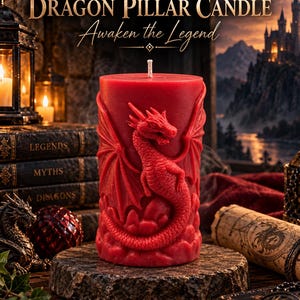 May include: A cylindrical red pillar candle featuring a detailed embossed dragon design wrapping around the exterior. The candle has a single white wick at the top and is positioned on a textured stone base. Text reads DRAGON PILLAR CANDLE Awaken the Legend.