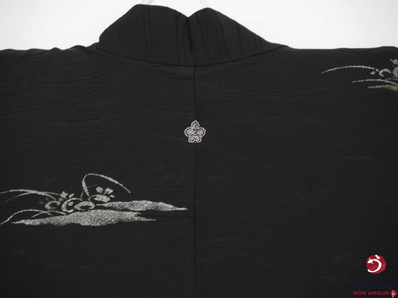 K&ouml;nnte beinhalten: Schwarzer Seidenkimono mit silberner Blumenstickerei. Der Kimono hat ein traditionelles japanisches Design mit einem Blumenmotiv auf der R&uuml;ckseite.