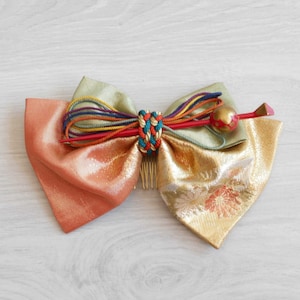 Kanzashi Japanese hair ornament in green, red and gold fabric with red and gold lacquered pin