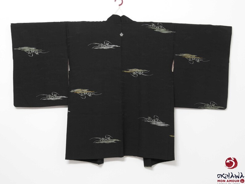 K&ouml;nnte beinhalten: Ein schwarzer japanischer Kimono mit einem traditionellen Design aus wei&szlig;en und goldenen Wolken. Der Kimono hat einen schlichten, eleganten Stil und ist perfekt f&uuml;r besondere Anl&auml;sse.