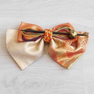 Kanzashi Japanese hair ornament in orange, beige and gold fabric with red and gold lacquered pin