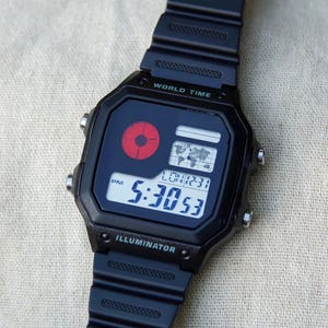 Japan Underground – Reloj modificado basado en el Casio AE-1200 – Pantalla de punto rojo, carátula negra, correa táctica Hydro Mod – Casio Royale personalizado