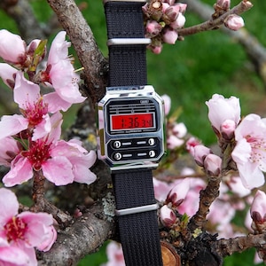 Píldora Roja: Reloj modificado basado en el Casio A100. Reloj digital personalizado con pantalla roja invertida y correa NATO negra. Idea de regalo retro Casio Mod.