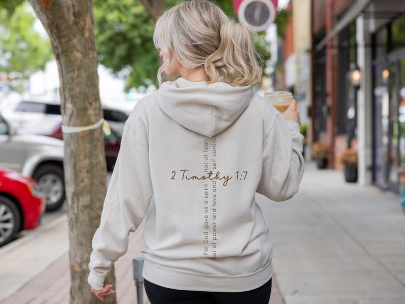 Gildan 18500 oversized sweatshirt in the color sand with a bible verse on the back. On the front of the sweatshirt the text reads Fearless in bold print. This minimalist comfy sweatshirt is perfect for the gym, the street or just for casual wear.