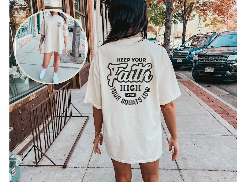 May include: A white oversized t-shirt with a black graphic that says "Keep Your Faith High and Your Squats Low".
