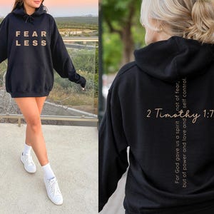 Gildan 18500 oversized sweatshirt in the color black with a bible verse on the back. On the front of the sweatshirt the text reads Fearless in bold print. This minimalist comfy sweatshirt is perfect for the gym, the street or just for casual wear.