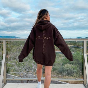 Gildan 18500 oversized sweatshirt in the color brown with a bible verse on the back. On the front of the sweatshirt the text reads Fearless in bold print. This minimalist comfy sweatshirt is perfect for the gym, the street or just for casual wear.