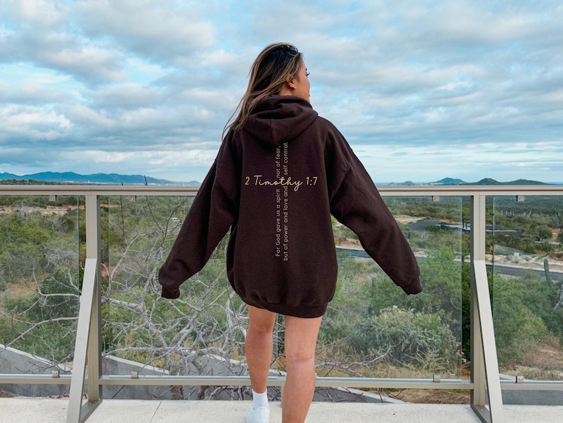 Gildan 18500 oversized sweatshirt in the color brown with a bible verse on the back. On the front of the sweatshirt the text reads Fearless in bold print. This minimalist comfy sweatshirt is perfect for the gym, the street or just for casual wear.