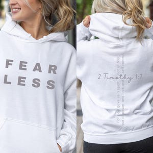 May include: White hoodie with the word "FEARLESS" printed on the front in grey lettering. The back of the hoodie has the text "For God gave us a spirit not of fear, but of power and love and self-control. 2 Timothy 1:7" printed in grey lettering.