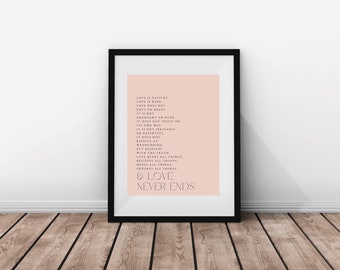 May include: A framed wall art print featuring a pale pink background with black text. The text reads: Love is patient, love is kind, love does not envy or boast, it is not arrogant or rude, it does not insist on its own way, it is not irritable or resentful, it does not rejoice at wrongdoing, but rejoices with the truth, love bears all things, believes all things, hopes all things, endures all things, and love never ends.