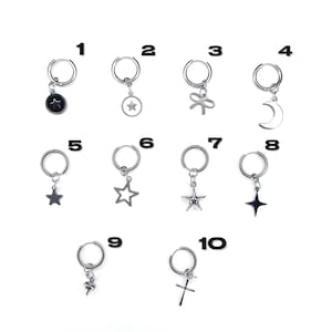 Peut inclure: Dix paires de boucles d'oreilles créoles argentées avec différents pendentifs, dont une étoile, un croissant de lune, un nœud, une croix et un cœur. Les boucles d'oreilles sont numérotées de 1 à 10.