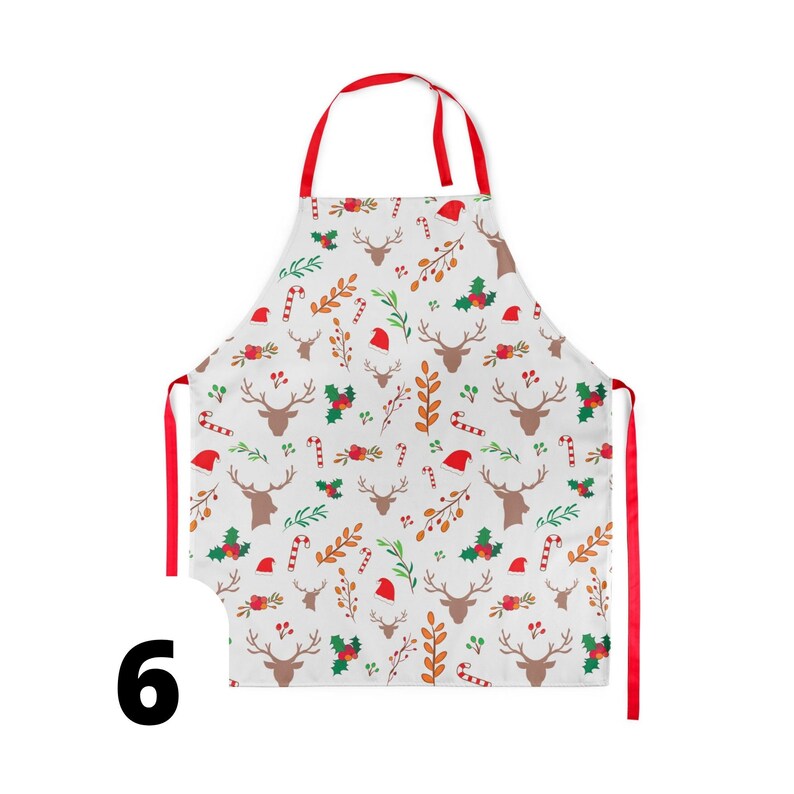 Pu&ograve; includere: Un grembiule da cucina rosso e bianco a tema natalizio con un motivo di renne, bastoncini di zucchero, agrifoglio e alberi di Natale.