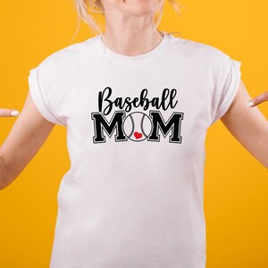 May include: White t-shirt with the words "Baseball MOM" in black script and block letters. A baseball with a red heart is in the center of the word "MOM". The shirt is on a person with a yellow background.