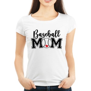 May include: White t-shirt with the text "Baseball MOM" in black script and block letters. A baseball graphic with a red heart replaces the "O" in MOM. The shirt is a crew neck style.