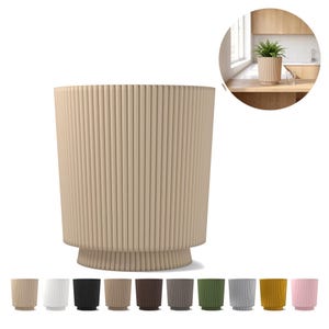 Op de afbeelding: Een cilindervormige plantenbak met een verticaal geribbelde textuur en een licht uitlopende voet. De plantenbak is uitgevoerd in een neutrale beige kleur, met een ronde inzetfoto in een keukenomgeving en een rij met kleurvariaties eronder.