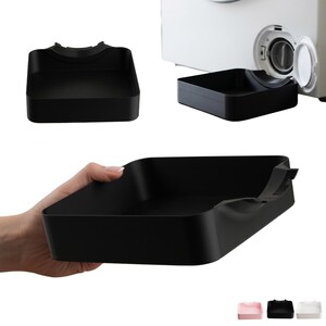 Peut inclure: Un bac de récupération rectangulaire en plastique noir conçu pour le filtre de vidange d'un lave-linge. Le bac présente une découpe incurvée sur un côté pour s'ajuster sous la trappe circulaire du filtre, récupérant l'eau lors de l'entretien.