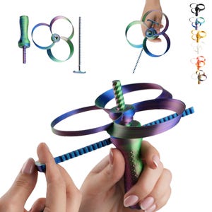 Pode incluir: Um brinquedo iridescente de mão com cabo texturizado, uma hélice de três alças e um mecanismo de tira serrilhada. Os componentes são mostrados desmontados e montados em um gradiente de cores metálicas azul, verde e roxo.