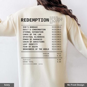 May include: Ivory long-sleeve shirt with the text "REDEMPTION" printed on the back. The text is followed by a list of items, including "Sin's Bondage", "Guilt & Condemnation", "Eternal Separation", "Curse of the Law", "Spiritual Blindness", "Power of Darkness", "Chain of Addictions", "Lost Identity", "Fear of Death", and "Brokenness of the World". Each item is followed by the word "Redeemed". Below the list is a receipt with the words "Ransom", "Change", "Paid", "Subtotal", and "Grand Total".