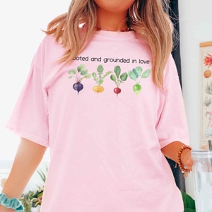 May include: Pink t-shirt with a graphic of five colorful beets and the text "Rooted and grounded in love".