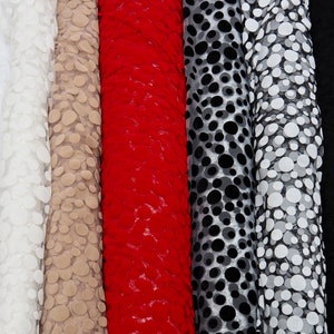 May include: Five rolls of fabric with different patterns. The fabric is white with white polka dots, beige with beige polka dots, red with red polka dots, black with black polka dots, and white with black polka dots.