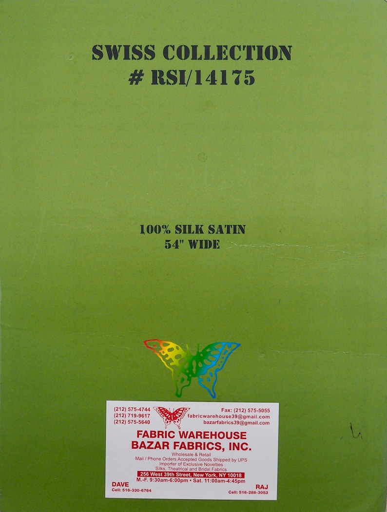 May include: Green card with white text that reads "Swiss Collection #RSI/14175 100% Silk Satin 54" Wide". Below the text is a colorful butterfly illustration. The card also includes contact information for Fabric Warehouse Bazar Fabrics, Inc. with phone numbers, fax number, and email addresses. The card also includes the company's address and business hours.