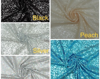 May include: Four swatches of sequined fabric in different colors: black, peach, silver, and teal. The fabric is textured and has a subtle shimmer.