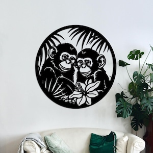 Könnte beinhalten: Schwarz-weiße Silhouette von zwei Affen, die zusammen in einem Kreis mit einem tropischen Blattdesign sitzen. Die Affen halten eine Blume.