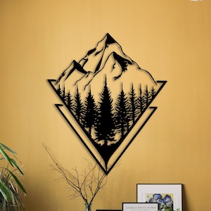 May include: Black metal wall art featuring a mountain range with trees in a geometric design. The art is mounted on a yellow wall in a room with furniture and plants.