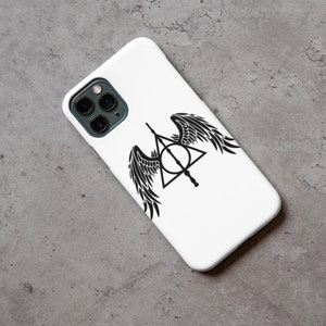 Puede incluir: Carcasa de tel&eacute;fono blanca con un gr&aacute;fico negro del s&iacute;mbolo de las Reliquias de la Muerte con alas.