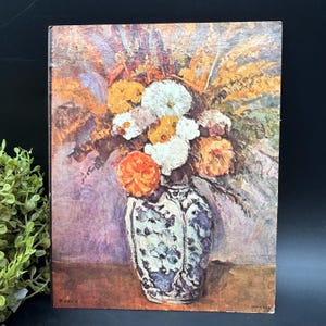 May include: A painting of a bouquet of flowers in a blue and white porcelain vase. The flowers are white, yellow, and orange. The background is a purple and brown color.