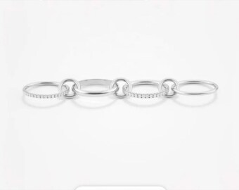Könnte beinhalten: Fünf silberne Ringe, einige mit einer Reihe kleiner Diamanten, sind miteinander verbunden.