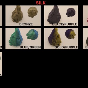 May include: A collection of eight gnome figurines with different color combinations. The gnome figurines are made of a silk material and have a shiny finish. The colors include copper, bronze, black, purple, gold, magenta, rose red, blue, green, dark gold, and emerald green.