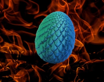 Può includere: Un uovo di drago blu con una superficie testurizzata e squamosa. L'uovo è posto su uno sfondo di fiamme arancioni.