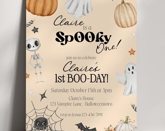 May include: A Halloween-themed invitation with a light beige background. The invitation features illustrations of pumpkins, ghosts, bats, and a spiderweb. Text reads "Claire is a Spooky One!" and announces Claire's 1st BOO-DAY!