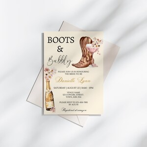 May include: A bridal shower invitation with a watercolor illustration of a cowboy boot, a champagne bottle, and a glass of champagne. The text reads "Boots & Bubbly" and includes the bride-to-be's name, Danielle Lynn, the date and time of the event, and the venue name and address. The invitation also includes a request to RSVP by August 1st.