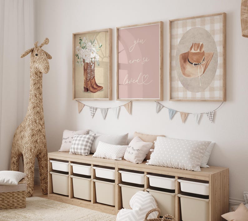 May include: Three framed prints with a pink and white color scheme. The prints feature a pair of cowboy boots with flowers, a pink background with the text "you were so loved", and a brown cowboy hat on a white and brown gingham background.